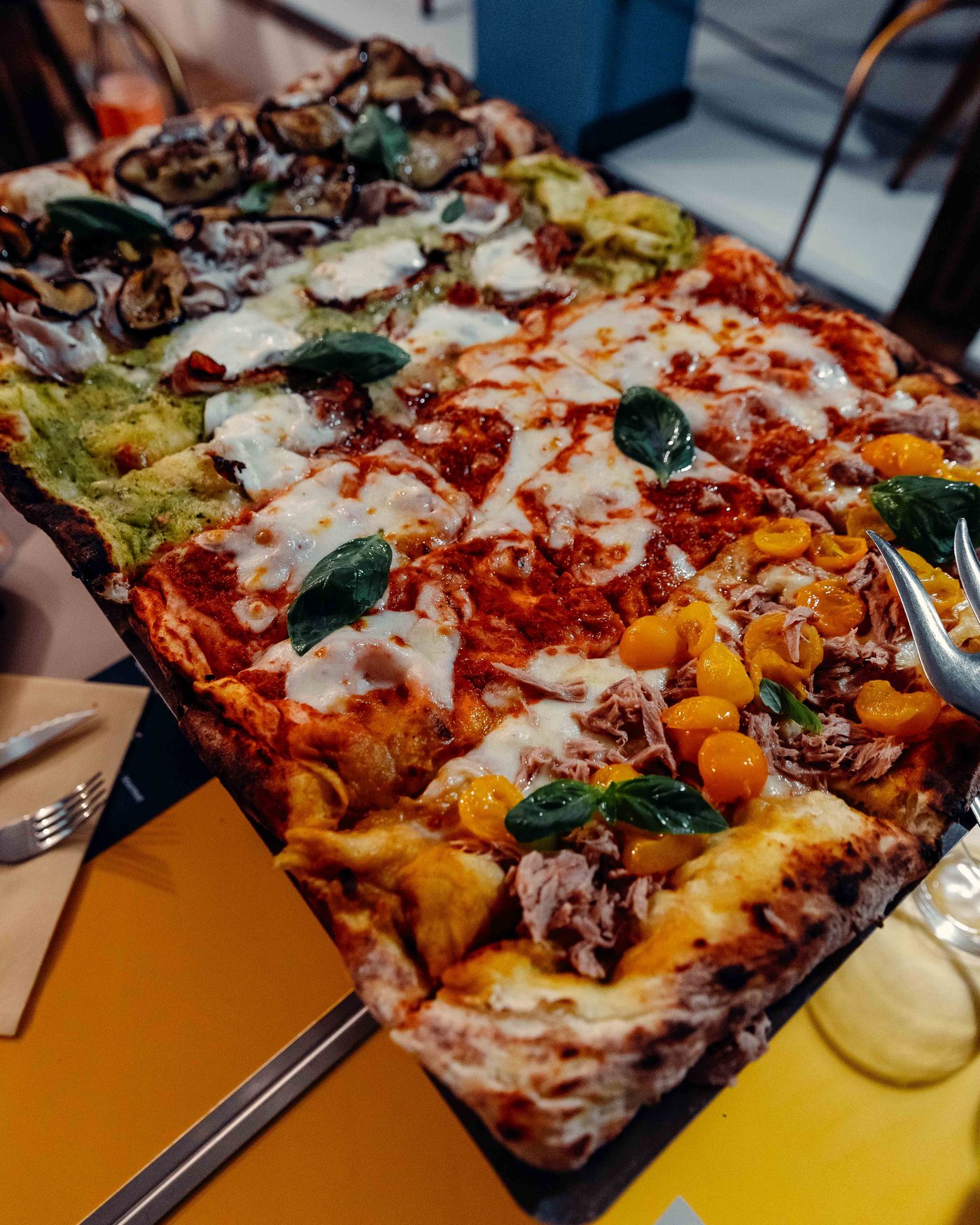 La Brace Intera di Pulcinè sollevata al tavolo, quattro gusti diversi sulla stessa pizza