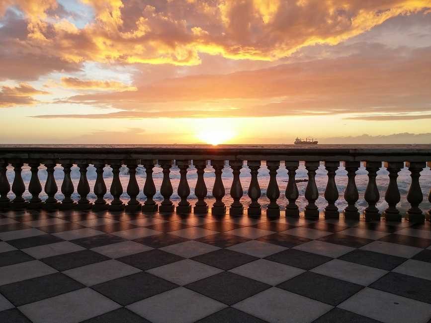 La Terrazza Mascagni di Livorno al tramonto, con una nave all'orizzonte — la pizzeria Pulcinè è proprio di fronte